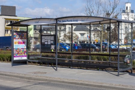 Przystanek autobusowy przy placu Jana Pawła II. Przez oszklone ściany można zobaczyć siedzibę Urzędu Miasta: fragment ratusza i budynku przy ulicy Wodnej.