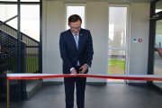 Prezydent Ciechanowa przecina biało-czerwoną wstęgę, otwierając zakład