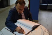 A. Struzik wpisuje się do pamiątkowej księgi szkoły