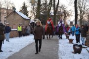 Czoło orszaku wchodzi za kościelną bramę. Na czele mężczyzna z gwiazdą na długim drzewcu, dalej konno jadą trzej królowie, za nimi uczestnicy orszaku