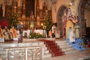 Ołtarz kościoła farnego. Po lewej siedzą księża, po prawej święta rodzina z Matką Bożą, dzieciątkiem, św. Józefem i aniołkiem