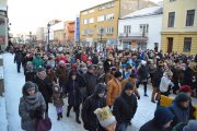 Uczestnicy Orszaku Trzech Króli idą ulicą Warszawską. Widać wielu ludzi - dorośli i dzieci