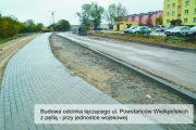 Budowa odcinka łączącego ul. Powstańców Wielkopolskich z pętlą - przy jednostce wojskowej. Po prawej gotowy chodnik. Po lewej pas gruntu pod jezdnię ograniczony krawężnikami