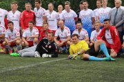 Pamiątkowe zdjęcie obu drużyn rozgrywających mecz z Gwiazdami. Zawodnicy w piłkarskich strojach. Część z nich stoi, część kuca, a dwóch zawodników leży