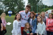 Grupka dziewczynek ustawiła się do pamiątkowego zdjęcia z aktorem Krzysztofem Wieszczkiem