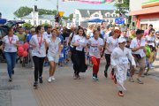 Rusza bieg przeciwko białaczce. Jako pierwszy biegnie chłopiec w Doboku - stroju taekwondo, trochę w głębi biegną dorośli z malutkimi dziećmi
