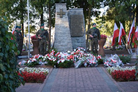 Kwatera Wojska Polskiego i Ofiar Terroru na cmentarzu komunalnym. Dwie pionowe czworoboczne kolumny. Na jednym równoramienny krzyż, na drugim tablica z informacją. Po obu stronach żołnierz stojący na warcie