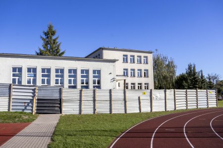 Budynek szkoły nr 6 oddzielony blaszanym ogrodzeniem od boiska i szkolnej bieżni.